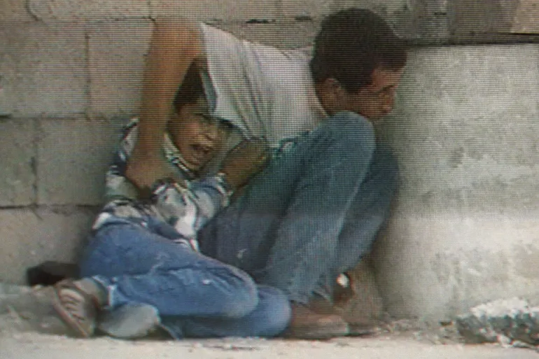 Frightened Muhammad al-Durrah hiding behind his father before being killed by the IOF